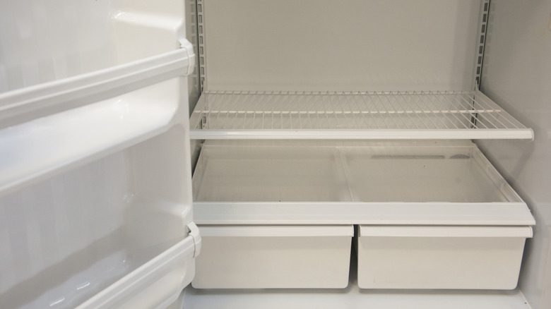 Bottom shelves and crisper drawers of an empty refrigerator