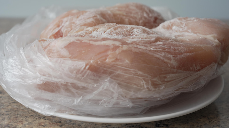 Raw chicken on a plate sitting on kitchen counter