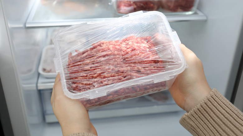 Person taking meat out of a refrigerator