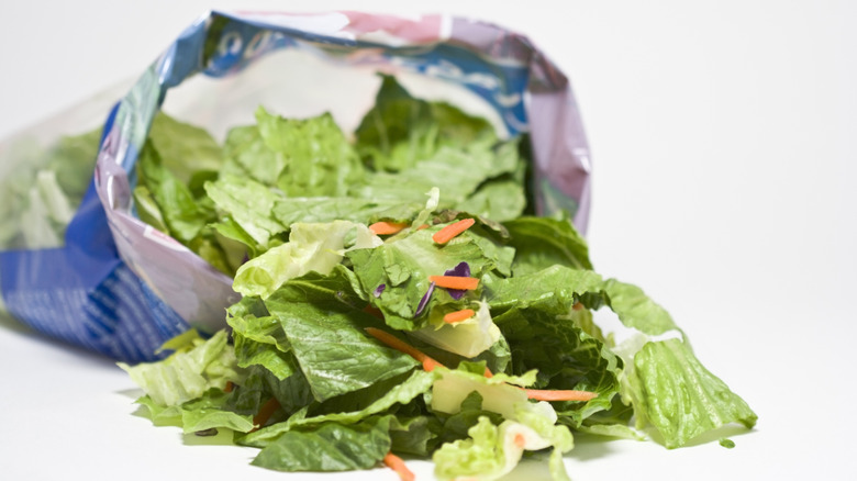 An opened bag of packaged salad