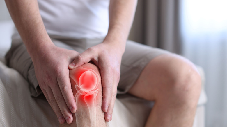 A man grabbing his injured knee