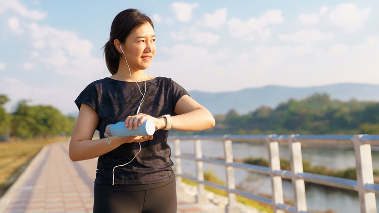 Woman checking smartwatch while on an outdoor walk