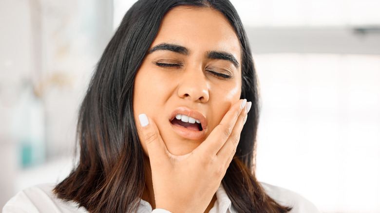 Woman holding the side of her face from a toothache